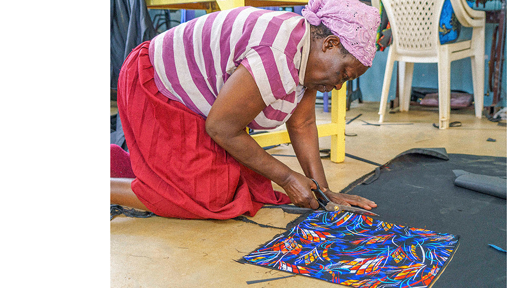 Woman cutting cloth on floor